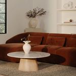 Side angle of sectional in living room context with round wooden and marble coffee table