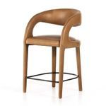 Hawkins stool angled view showing smooth leather curves and black metal footrest