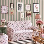 Wallpaper in a living room setting behind floral upholstered sofa, with framed art on the wall