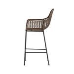 Side view showing the profile of woven seat and armrest with iron legs