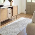 Elle Sage Dusty Sage rug shown as a narrow runner in a sunny entryway with wood flooring and light wood furniture