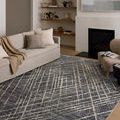 Wade Midnight / Beige Rug styled in modern living room with neutral sofa, fireplace, and decorative shelving