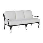 Outdoor sofa with white cushions and black aluminum frame featuring curved arms and decorative legs
