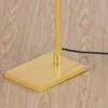 Close-up of Narragansett floor lamp square aged brass base and black power cord on wood floor