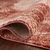 Rug rolled on dark wood floor highlighting dense polypropylene pile and tightly woven backing