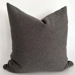 Graphite gray pillow shown at a slight angle against neutral background highlighting shape and fabric weave