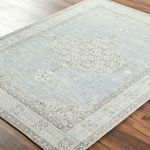 Close-up angled view showing the texture and detailed pattern of the Lila Denim/Seafoam rug on wood floor