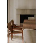 Side view of two Remy Dining Chairs lined up at a dining table next to light fabric chairs.