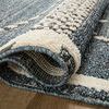Rolled end of Fabian Denim charcoal rug displaying pile thickness and woven backing