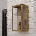 Antique brass Royster Outdoor Wall Sconce mounted at an angle on white brick wall in daylight