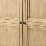 Detail of cabinet doors with metal knobs and defined rectangular paneling.
