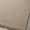 Close-up on woven texture showing subtle tonal beige variation and fringe on edge