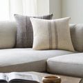 Brett lumbar pillow on gray sectional sofa paired with a dark brown textured pillow and natural light through nearby window
