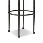 Detail of hammered iron legs with linked circular footrest and rounded ball feet on stool base