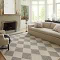 Francis rug in bright sitting area with cream sofa, side table, large windows, and fireplace with tall mirror above