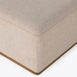 Side view of ottoman emphasizing wood base and clean fabric lines
