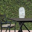Monterey Dining Chair at outdoor patio with black dining table and green ivy wall background