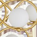 Close-up of milky white glass globes and textured gold leaf wrought iron loops