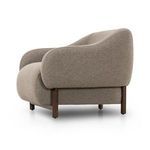Side angled view emphasizing the rounded form of the armrests and wooden leg structure