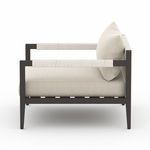 Side profile showing wrapped armrests and deep seat cushion of outdoor chair