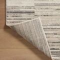 Back side of Darby Charcoal / Sand rug folded over showing woven backing and edge finish