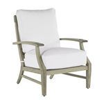 Outdoor lounge chair with teak frame in natural finish and plush white cushions on seat and back