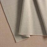 Close-up of rugs folded to show texture and color variations in taupe and beige