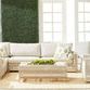 Outdoor living set with side table placed between woven outdoor sofa and armchair with natural fiber rug
