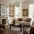 Taupe and ivory rug styled in a cozy living room under a dark wood coffee table with cream sofa and armchairs
