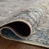 Rolled edge of rug highlighting textured polyester weave and underside showing pile thickness