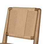 Close-up detail of woven natural fiber backrest wrapped around rounded wood frame