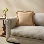rust red pillow styled on light beige fabric sofa in living room setting
