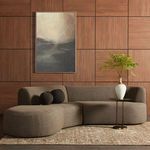 Sectional shown in a room setting with wood paneled wall, decorative pillows, and side table with vase.