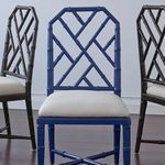Front view of Jardin Side Chair showing detailed lattice fretwork and tapered legs alongside contrasting dark brown chairs