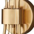 Macro detail of brushed brass wallplate and narrow gold stems holding leaf detail