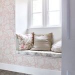 Rachel Ashwell Stipple Wallpaper installed on wall beside window seat with floral and neutral cushions