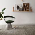 Giana rug styled in room with modern chair, side table, and wall art on floating wooden shelf