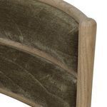 Close-up angled view of velvety fabric on tufted backrest with wood frame edges