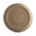 Underside bottom of plate showing unglazed speckled clay base with circular foot and concentric rings
