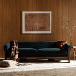 Repeat of side close-up spotlighting velvet arm and wood leg texture