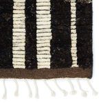 Close-up of fringe and the border where dark brown pattern meets ivory stripes with visible texture