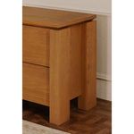 Close-up of the nightstand leg and drawer side showing oak texture and finish