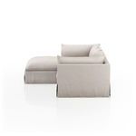 Side view revealing solid slipcover fabric fully covering sectional frame with loose back cushions