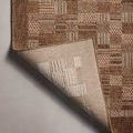 Corner of rug lifted to show finely woven backing and edge binding contrast.