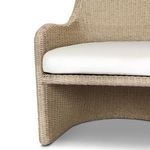 Close-up of lower front corner showing tightly woven wicker and cushion edge