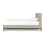 Side elevation of bed showing headboard thickness and upholstery with pillows against white sheet