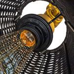 View inside rattan shade showing vintage-style exposed light bulb with patterned glass