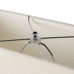 Close-up of chrome finial and support arms securing the fabric lamp shade