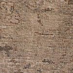 close-up showing vintage rug's distressed pattern and woven fabric texture