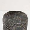Close-up of mid-section of the textured ceramic base carved with flowing folk art lines